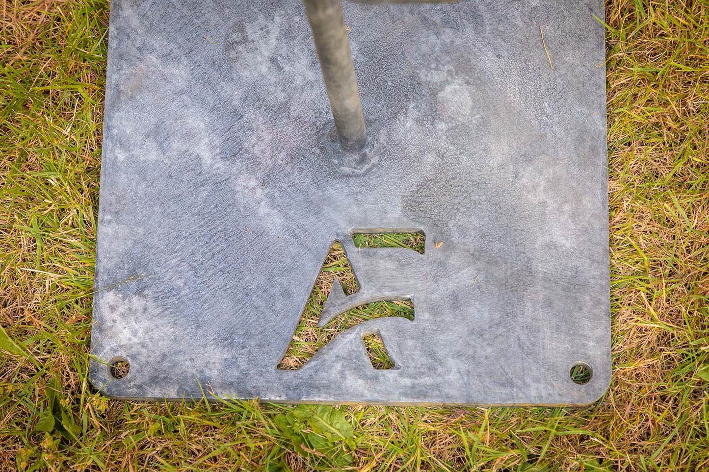 Metal sign with a symbol on grass